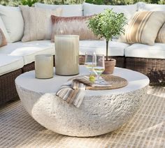 a table that has some wine glasses and a candle on it in front of a couch