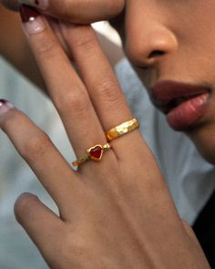 Looking for a tiny, exquisite symbol of love to bring with you? Then this ring will catch your eye. It is crafted with a vibrant red carnelian stone—known as the love stone—beautifully shaped into a heart that exudes warmth, passion, and romance. The nature stone's rich hue is perfectly complemented by the gold trim, which, upon closer inspection, reveals a retro strata finish. When you love love, you'll love this ring.❤️ Materials: 18k gold plated brass, carnelian stone Measurements: available Red Heart-shaped Promise Jewelry, Handmade Red Heart-shaped Rings, Red Gemstone Enamel Ring Gift, Red Enamel Ring With Gemstone Gift, Red Enamel Gemstone Ring For Gift, Red Dainty Stackable Rings, Red Dainty Heart Ring For Valentine's Day, Red Promise Heart Ring, Carnelian Amber Rings For Gifts