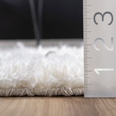 a ruler is on the floor next to a white rug