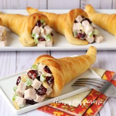 two white plates with cranberry chicken rolls on them and a fork in the middle