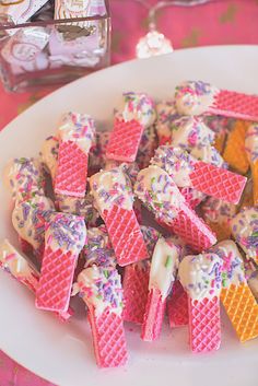 a plate full of waffles and ice cream on a table with candy in the background