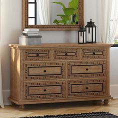 a wooden dresser sitting in front of a window with a mirror on top of it