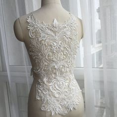 a mannequin with white lace on it in front of a window