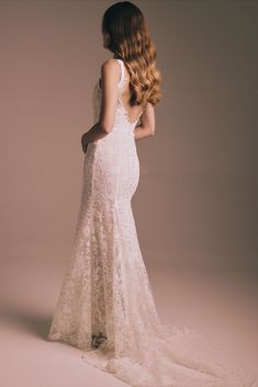 the back of a woman's wedding dress, with long hair in her left hand