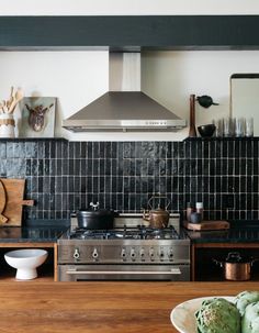 a stove top oven sitting inside of a kitchen next to wooden counter tops and cabinets