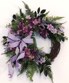 a wreath with purple flowers and green leaves