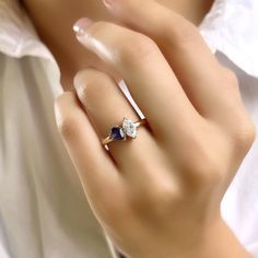 a woman's hand with a diamond and sapphire ring