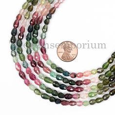 multicolored faceted glass beads with coin on white background