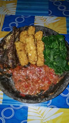 a plate filled with different types of food on top of a blue and yellow table cloth