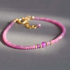 Dainty beaded bracelet with a row of exquisite, candy pink sapphire roundels. In the midst of these beautiful faceted gems, set apart by couple of gold filled roundels sits a a small nugget of star cut, silver sheen, pink sapphire nugget. Made adjustable from 7.25 to 8.5 inches. Sweet on its own, perfect for layering, amazing gift for someone special. Thank you for looking! Please contact me if you have any questions or requests. Free domestic First Class shipping. Gift wrap included and always Pink Faceted Rondelle Beaded Bracelets, Dainty Faceted Beaded Bracelets, Pink Rondelle Bracelet With Faceted Beads, Pink Rondelle Bracelets With Faceted Beads, Pink Faceted Rondelle Beads Bracelet, Faceted Rondelle Beaded Bracelets As Gift, Pink Rondelle Gemstone Beads Bracelets, Faceted Yellow Gold Beaded Bracelets, Pink Jewelry With Faceted Round Beads