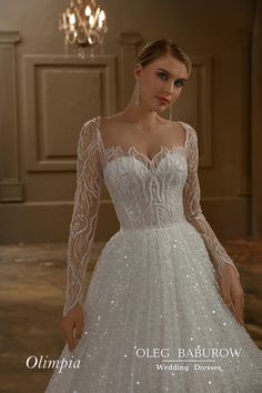 a woman wearing a wedding dress with long sleeves and beading on the bouncy