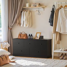 a bedroom with clothes hanging on the wall and shoes on the dresser in front of it