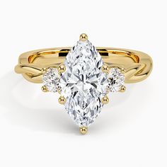 a yellow gold ring with an oval cut diamond and three smaller round diamonds on the band