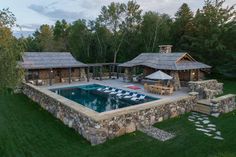 an aerial view of a house with a swimming pool and patio area in the foreground