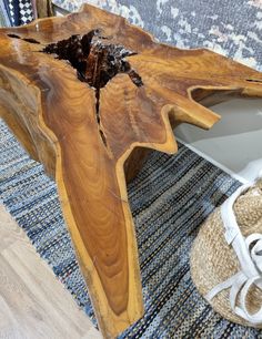 a wooden table sitting on top of a blue rug next to a white sneaker