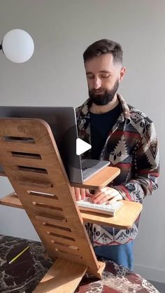 a man standing in front of a computer desk with a laptop on top of it