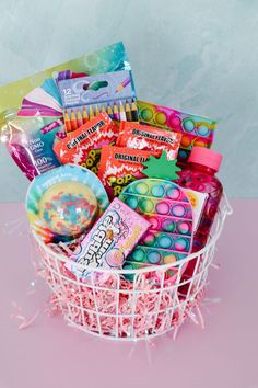 a basket filled with lots of colorful items on top of a pink tablecloth covered floor