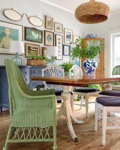 a dining room table with chairs and pictures on the wall