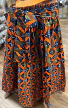 This  is a beautiful ethnic skirt that has an elastic waist band that allows it to fit multiple sizes. A waist tie belt and pockets on the sides for comfort and play. The Length 28 inches long.  Colors Orange , & Blue. Why not add this to your collection of wearable art today, Please don't delay. Bohemian Long Wrap Skirt With Batik Print, Traditional Long Wrap Skirt For Spring, Traditional Multicolor Long Wrap Skirt, Multicolor Lined Wrap Skirt, Traditional Multicolor Maxi Skirt, Bohemian Multicolor Flared Wrap Skirt, Multicolor Long Lined Wrap Skirt, Traditional Wrap Skirt For Spring, Traditional Relaxed Maxi Skirt With Lining