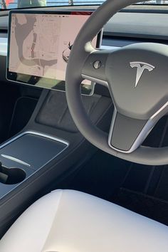 the interior of a car with a steering wheel, dashboard and display screen showing information