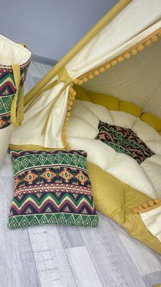 two pillows are sitting on the floor next to a teepee tent