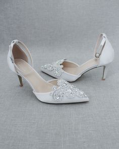 a pair of white wedding shoes with crystal embellishments