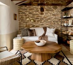 a living room filled with furniture and stone walls