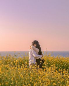 two people hugging in a field of yellow flowers