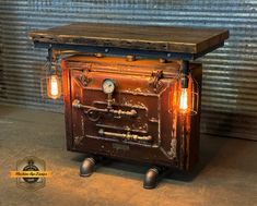 an old fashioned stove sitting on wheels in front of a metal wall with two light bulbs