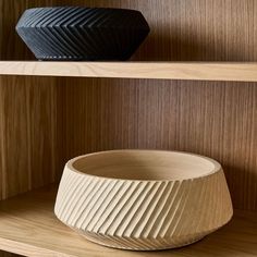 two wooden bowls sitting on top of shelves