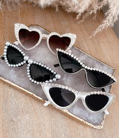 three pairs of heart shaped sunglasses with pearls