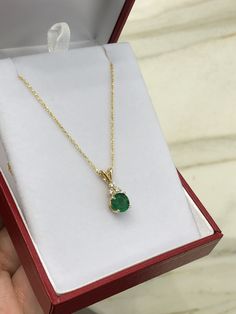 Featured here is a stunning, round natural emerald & diamond necklace in fine 14K yellow gold. Displayed is a medium-green emerald with very good transparency, accented by a simple four-prong mount allowing for the emerald to be shown in full view. The earth mined green emerald has a desirable rich green color with excellent qualities. Three diamond accents are placed on top of the emerald! This pendant is ideal for everyday use and is the perfect accessory to any outfit. This pendant comes Green 14k Gold Necklace With Diamond Accents, 14k Gold Green Necklace With Diamond Accents, Fine Jewelry Green Diamond Necklace In 14k Gold, Green Diamond Necklace In 14k Gold, Exquisite Round May Birthstone Necklace, Yellow Gold Necklace With Diamond Accents For May Birthstone, Elegant Green Diamond Necklace In 14k Gold, Classic Yellow Gold Emerald Diamond Necklace, Round Emerald Necklace For Anniversary