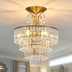 a crystal chandelier hanging from the ceiling in a living room with white walls