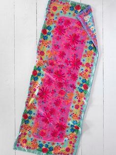 a pink and blue flowered sleeping bag on a white wooden floor