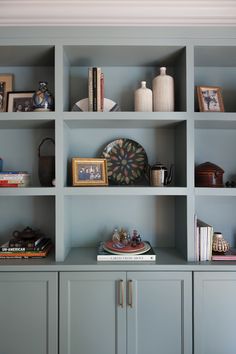 the bookshelves have many different items on them in this blue book shelf area