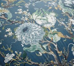 a blue and white flowered fabric with many different flowers on the back of it