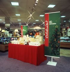 a christmas display in a store with red tablecloths and coca - cola signs