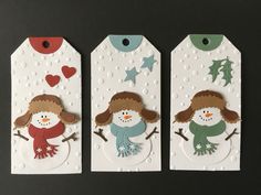 three tags with snowmen and stars on them