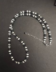 Navajo Pearls Sterling Silver Black Bead Necklace The necklace measures 22 inches. The necklace has 2 inch extender chain Handmade Southwestern Black Beaded Necklace, Black Single Strand Bohemian Jewelry, Bohemian Black Single Strand Jewelry, Handmade Southwestern Black Beads, Southwestern Black Beaded Necklaces For Gifts, Southwestern Black Beaded Necklace Gift, Southwestern Style Black Beaded Necklaces As Gift, Southwestern Style Black Beaded Necklaces For Gifts, Southwestern Style Black Beaded Necklace For Gift