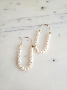 ∙These pearl hoop earrings are super femme and perfect for dressing up a simple outfit! Would also be wonderful for a bride with a bit of vintage flair. ∙Unique shape is sure to catch you some compliments. ∙Nice and lightweight on the ear! ∙Top quality materials are excellent for sensitive ears/skin. ∙These measure ~2.25 inches long. ~M A T E R I A L S ~ Choose from- * 925 Sterling silver *14k Gold fill *14k Rose gold fill **What is 14k Gold-fill?** Gold fill does not tarnish or wear off and con White Pearl Embellished Hoop Earrings For Wedding, Pearl Embellished Hoop Earrings For Wedding, Chic Pearl Embellished Earrings For Wedding, Delicate White Hoop Earrings With Pearl Drop, White Pearl Drop Hoop Earrings In 14k Gold, Pearl Chain Hoop Earrings For Wedding, Feminine Pearl Chain Earrings For Wedding, Elegant White Hoop Earrings With Pearl Chain, White 14k Gold Filled Bridal Earrings For Wedding