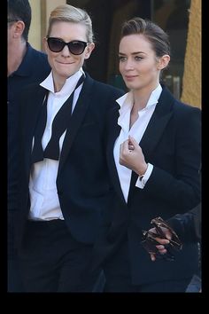 two people dressed in black and white walking together