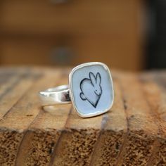 This adorable Rabbit ring will bring you joy every time you wear it. I carved the sterling silver ring setting from a block of wax, then cast that wax ring into metal and molded it so I can make multiples. This ring setting then gets a layer of vitreous enamel (fine glass) and fired at 1400 in a kiln four separate times to build strength and color saturation . Finally I take an illustration from my sketchbook, turn it into an enamel screen print, and fire that on the top for a durable, waterproo Handmade White Sterling Silver Signet Ring, Handmade White Signet Ring In Sterling Silver, Adjustable White Sterling Silver Signet Ring, Nickel-free Sterling Silver Signet Ring Gift, White Enamel Sterling Silver Ring As A Gift, White Sterling Silver Enamel Ring As Gift, White Gold Sterling Silver Enamel Ring For Gift, White Gold Sterling Silver Enamel Ring As Gift, Hand Cast White Sterling Silver Jewelry