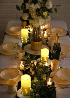 the table is set with candles and plates