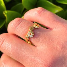 a woman's hand holding a ring with flowers on it