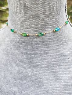 Super dainty emerald green crystal beaded choker made from gold plated stainless steel and beautiful little long green crystals. PLEASE read my shop announcement before placing an order so you know what to expect right now. Plus, when ordering from outside Europe, don't forget to provide a phone number for the courier to ensure the fastest and smoothest delivery Stainless steel chain and findings, won't rust or anything  Fastens with a solid lobster clasp, and has an extension chain.   Choker is Gold Beaded Necklaces For May Birthstone, Green Beaded Chain Jewelry, Beaded Emerald Jewelry Gift, Gold Beaded Emerald Necklace, Green Emerald Jewelry With Delicate Chain, Dainty Emerald Jewelry With Adjustable Chain, Green Beaded Chain Necklace As Gift, Green Beaded Clavicle Chain Necklace For Gift, Green Jewelry With Adjustable Chain And Round Beads