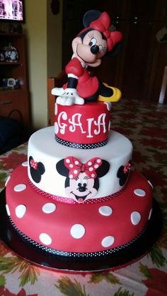 a three tiered cake with minnie mouse on top