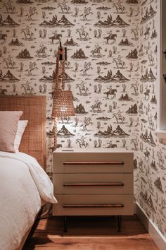 a bed room with a neatly made bed and wall paper