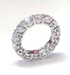 Our eternity band is a showstopper. Featuring round brilliant cut prong set cubic zirconia stones. Wear the band solo or stack with other rings, either way the look is luxurious. See our other bands for stacking. half sizes available. The ring on the right is also available. Item Details: TCW: 4.8 Style: Eternity Band Alternate Style: Cocktail Gender: Women's Stone Color: Clear Stone Cut: Round Stone Size: 4.5 mm Stone Material: Cubic Zirconia Stone Setting: Prong Ring Dimensions: 22 mm x 4.5 mm Dazzling Diamond White Eternity Band Promise Ring, Cubic Zirconia Eternity Band For Formal Occasions, Dazzling White Eternity Band With Vs Clarity, Diamond White Eternity Band Promise Ring, Cubic Zirconia Eternity Ring For Anniversary, Promise Ring Eternity Band With Prong Set Moissanite, Dazzling Eternity Band With Prong Setting, Dazzling Round Eternity Band With Prong Setting, Moissanite Eternity Band With Prong Setting For Promise Ring