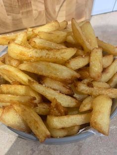 french fries sitting in a bowl on top of a table