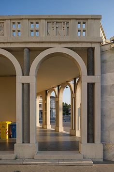 an arch in the middle of a building with columns and arches on both sides,